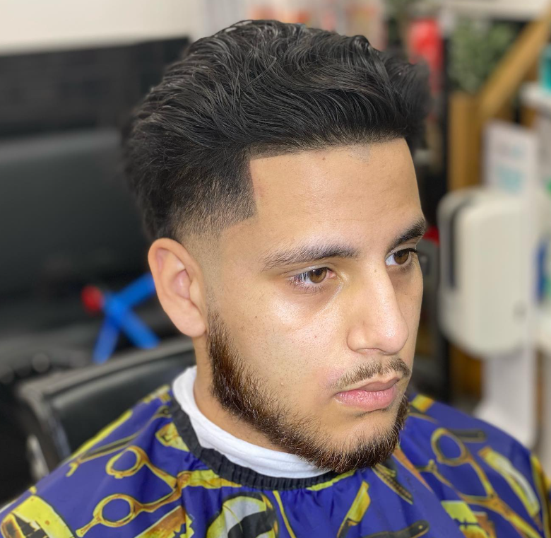 Textured haircut with a sharp line-up and beard trim
